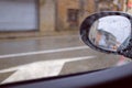 Window view inside a car on a rainy day with mirror car and urban landscape Royalty Free Stock Photo