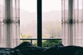 Window view nature green mountain in the bed at bedroom morning and raining in the rainy season - window glass with drapery , tone