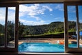 Window View to a Beautiful Swimming Pool by the Mountains in the Countryside of Brazil Royalty Free Stock Photo