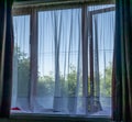 Window view witha net curtain and difussed view of the outside Royalty Free Stock Photo