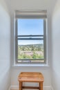 Window views of small city through window in a bright apartment small nook with a wood bench