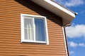 Window in wall of brown vinyl siding Royalty Free Stock Photo