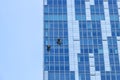 Window washers cleaning the glass facade of a modern building, high risk work Royalty Free Stock Photo