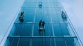 Window Washers Hanging from a Glass Skyscraper Royalty Free Stock Photo