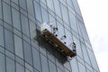 Window washing platform suspended on glass facade of a skyscraper Royalty Free Stock Photo