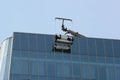 Window washing platform suspended on glass facade of a skyscraper Royalty Free Stock Photo