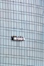 Window washing workers in the platform suspended on glass facade Royalty Free Stock Photo