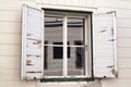 Window with white wooden old shutters.Row of ancient white weathered window shutters.Old window with white wooden shutters in an Royalty Free Stock Photo