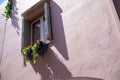 Window with wooden frame and a colorful flower box on a pink house facade in Rethymno Crete Royalty Free Stock Photo