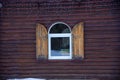 A window with wooden shutters against a cherry wood wall Royalty Free Stock Photo