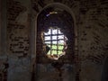 Windows of an ancient temple, in the wall of red brick, in the form of an arch. The hole in the wall is sealed with metal bars