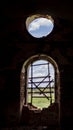 Windows of an ancient temple, in the wall of red brick, in the form of an arch. The hole in the wall is sealed with metal bars Royalty Free Stock Photo