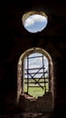 Windows of an ancient temple, in the wall of red brick, in the form of an arch. The hole in the wall is sealed with metal bars