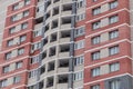 Windows and balconies of a high-rise building made of red and white bricks. Royalty Free Stock Photo