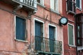 View of windows, balcony, clock and details of old cracked walls of buildings on the street in Venice, Italy Royalty Free Stock Photo