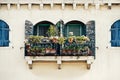 Windows with blue shutters and flowers on the yellow facade in old house in Venice Royalty Free Stock Photo