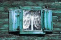 Windows with curtains and shutters at an old green-blue wooden house Royalty Free Stock Photo