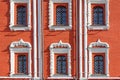 Windows with decorative metal grilles on the facade of red brick of ancient house closeup Royalty Free Stock Photo