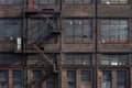 Windows, doors, and fire escape on the exterior of a derelict industrial building Royalty Free Stock Photo