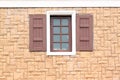 Windows of homes with brick wall surround.