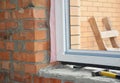 Windows installation. Inserting a upvc plastic window frame in a newly constructed brick house Royalty Free Stock Photo
