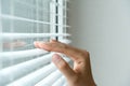 Windows jalousie. woman peeking through window blinds. Male hand separating slats of venetian blinds with a finger to Royalty Free Stock Photo