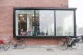 The windows of the kindergarten in a modern building and bicycles near the wall