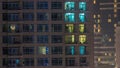 Windows of the multi-storey building of glass and steel lighting inside and moving people within timelapse Royalty Free Stock Photo