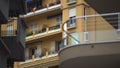 Windows of multistorey block of flats in European city, balconies with flowers