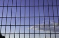 Windows in an office building, background. Blue sky reflected in the glass, black frames Royalty Free Stock Photo