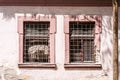 Windows on the old abandoned house used as prison during the war with metal safety gratings bars or grills from the outside Royalty Free Stock Photo