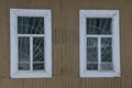 Windows of an old wooden house with metal bars Royalty Free Stock Photo