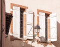 Windows with shutters and a lantern on the wall of the old house