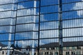 Windows of a skyscraper with reflection of blue sky and white clouds Royalty Free Stock Photo