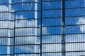 Windows of a skyscraper with reflection of blue sky and white clouds Royalty Free Stock Photo