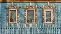 Windows on turquoise plank wall of old house with wooden carved architraves with cracked paint. Royalty Free Stock Photo