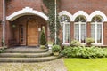 Windows and wooden door of red brick wall residence with garden Royalty Free Stock Photo