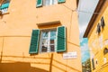 Windows on yellow painted facade of the house. Window with green shutters on a yellow house. Colorful architecture in Royalty Free Stock Photo