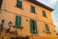 Windows on yellow painted facade of the house. Window with green shutters on a yellow house. Colorful architecture in Royalty Free Stock Photo