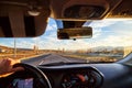 Windscreen view of nature, road, sun and hand of woman on the steering wheel in a spring, summer or autumn day. The concept of a