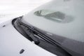 Windscreen wipers cleaning a windshield of a car from the snow Royalty Free Stock Photo