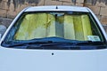 Windshield of car with protective reflective sunscreen surface inside car