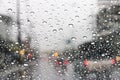 The windshield has rain water on the road when driving on the city streets