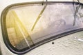 Windshield of a retro car after rain. Wet glass of a classic car with sunbeams