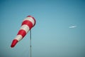 Windsock blown by the wind with airplane on a background Royalty Free Stock Photo