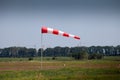 Windsock, weather vane for airfields. Red and white striped fabric showing wind speed, strength and direction. Umbrella cap at the