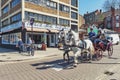 Tourists enjoying a sightseeing tour by a vintage hackney carriage drawn by white horses in the town of Windsor in Berkshire, UK Royalty Free Stock Photo