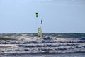 Windsurfer in big waves and kitesurfer in the air Royalty Free Stock Photo