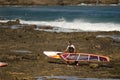 Windsurfer carrying his windsurf board.