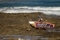 Windsurfer carrying his windsurf board.